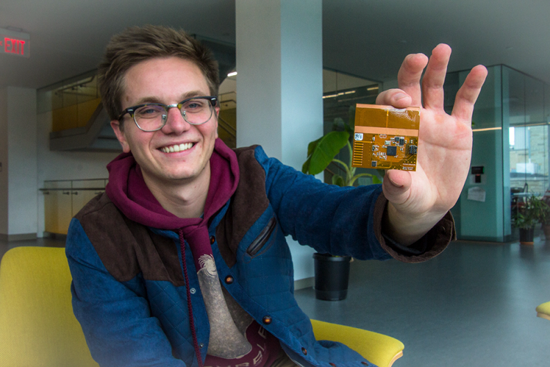 ECE lecturer Hunter Adams holding a “chipsat.” Below, the lab is set up for remote work.